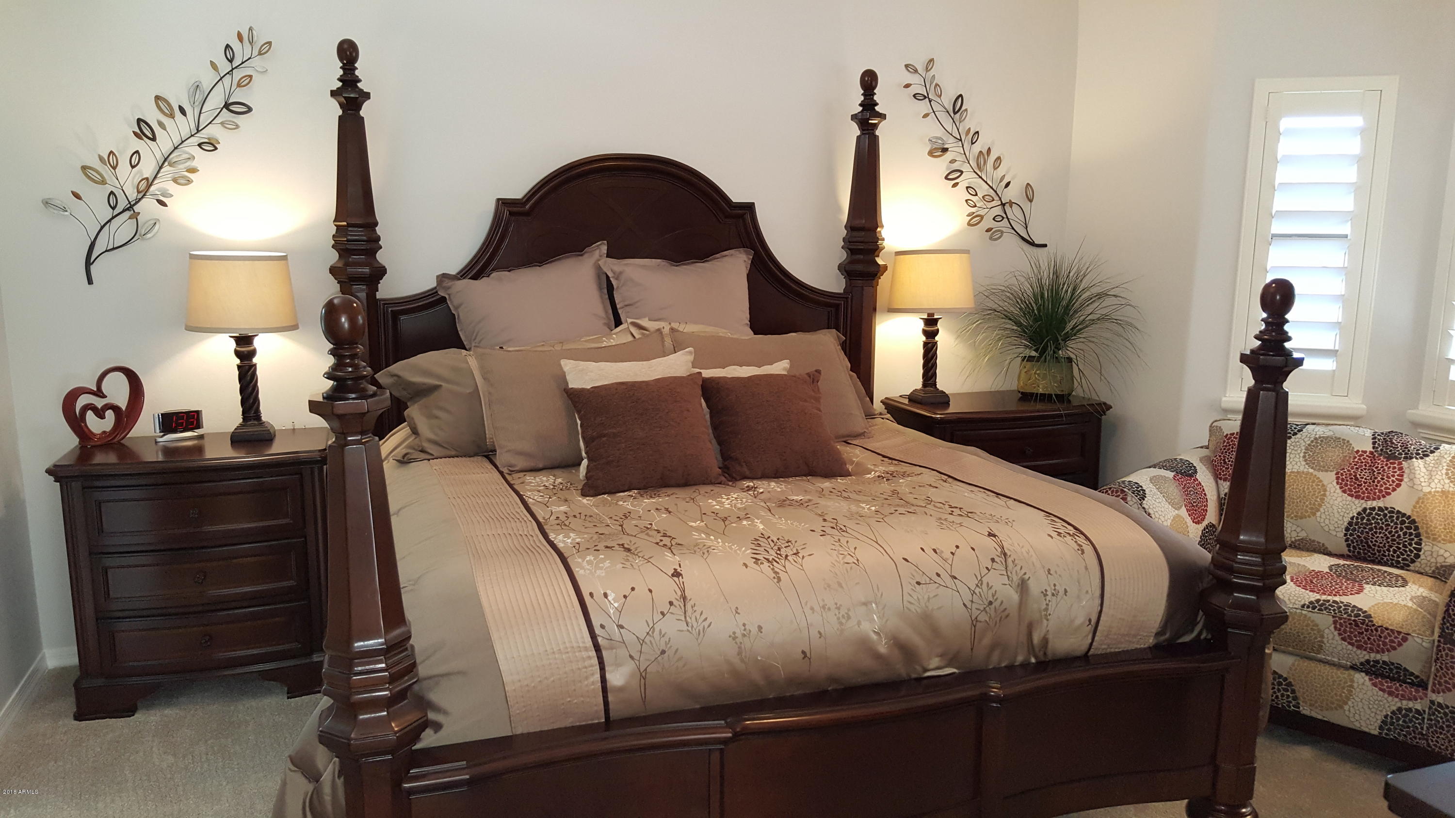 5830 East McKellips Road, Unit 75 Mesa, AZ 85215 - Photo 13 of 30 a bedroom with bed a night stand and a potted plant