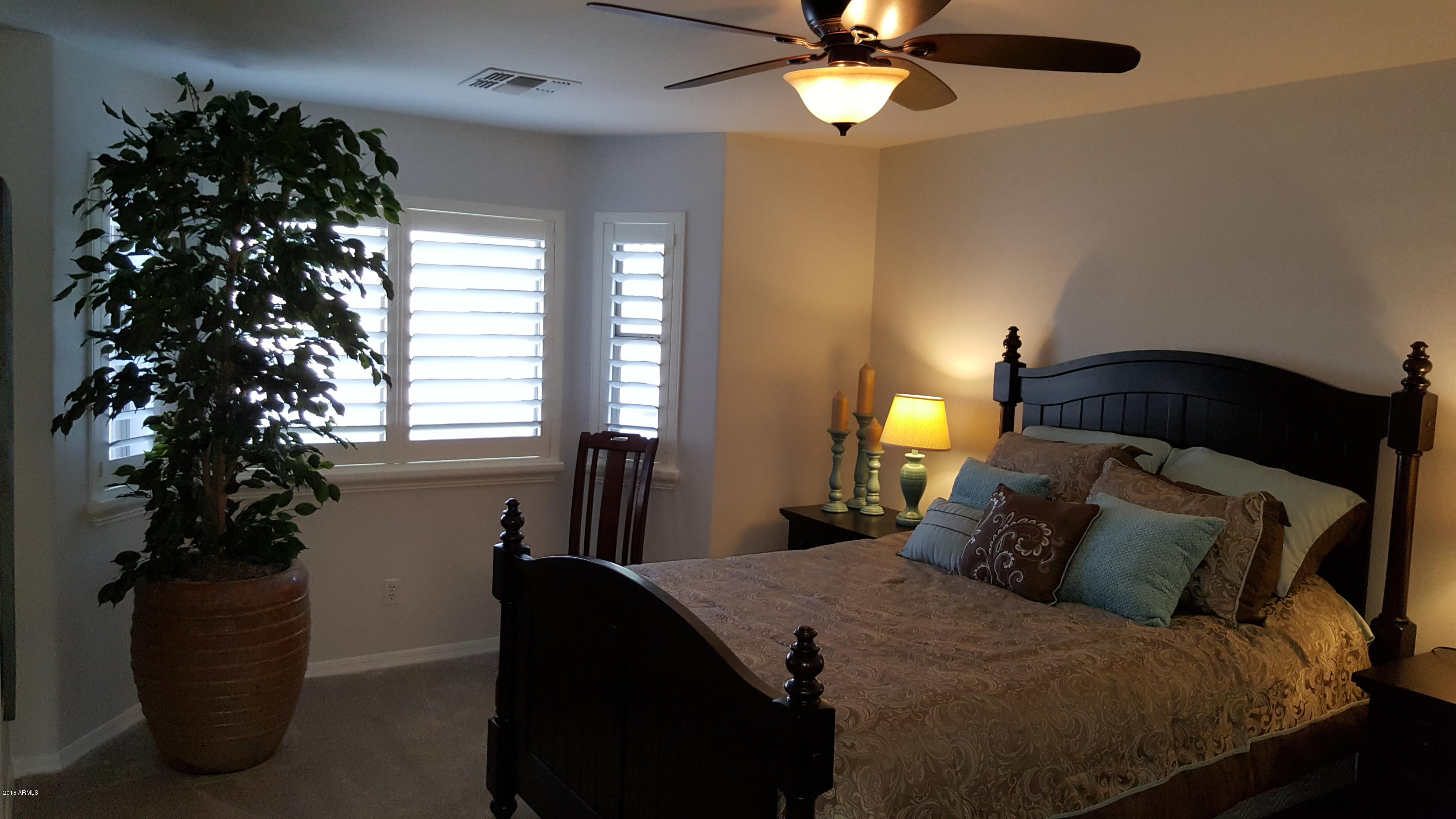 5830 East McKellips Road, Unit 75 Mesa, AZ 85215 - Photo 16 of 30 a bedroom with a bed and a chandelier