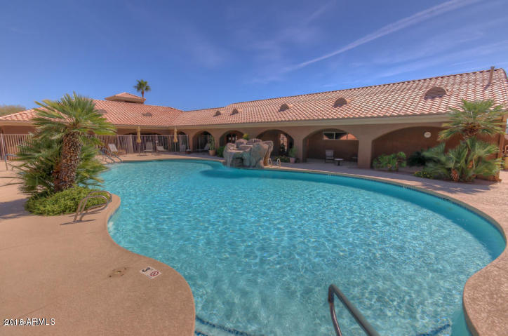 5830 East McKellips Road, Unit 75 Mesa, AZ 85215 - Photo 22 of 30 a view of a patio with table and chairs potted plants with wooden fence