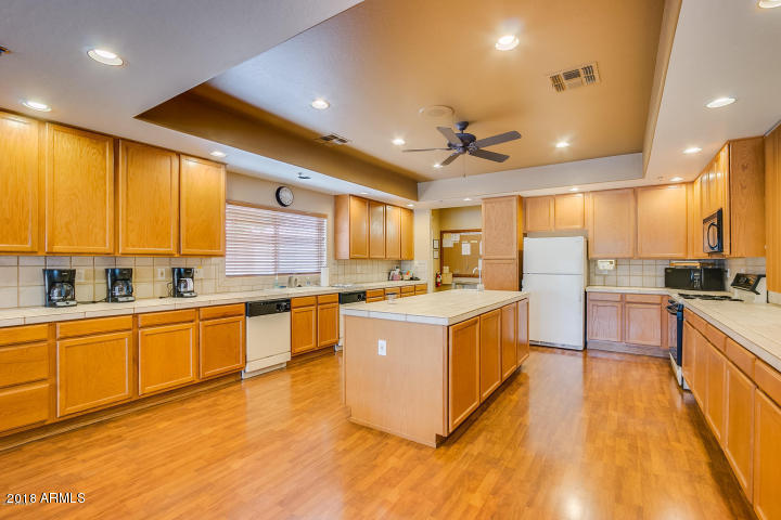 5830 East McKellips Road, Unit 75 Mesa, AZ 85215 - Photo 28 of 30 a large kitchen with stainless steel appliances granite countertop a large center island and a sink