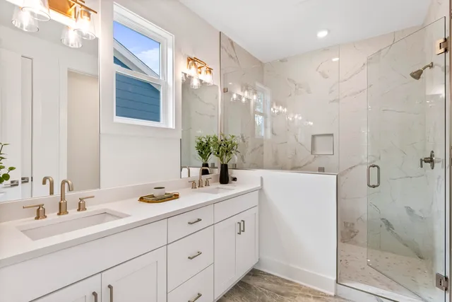 a bathroom with a double vanity sink mirror and shower