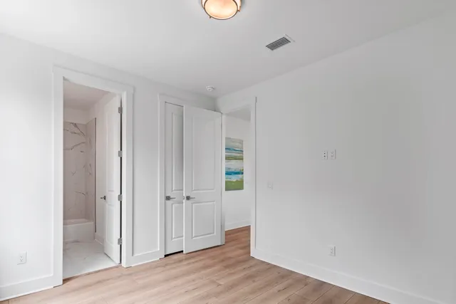 an empty room with wooden floor and window