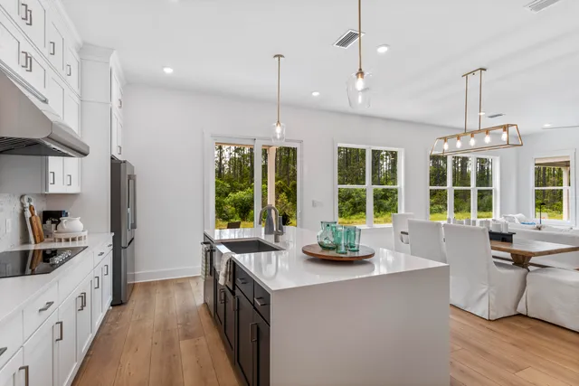 a kitchen with kitchen island a large counter top space a sink a window and stainless steel appliances