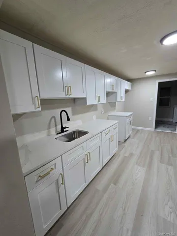 a kitchen with white cabinets and sink