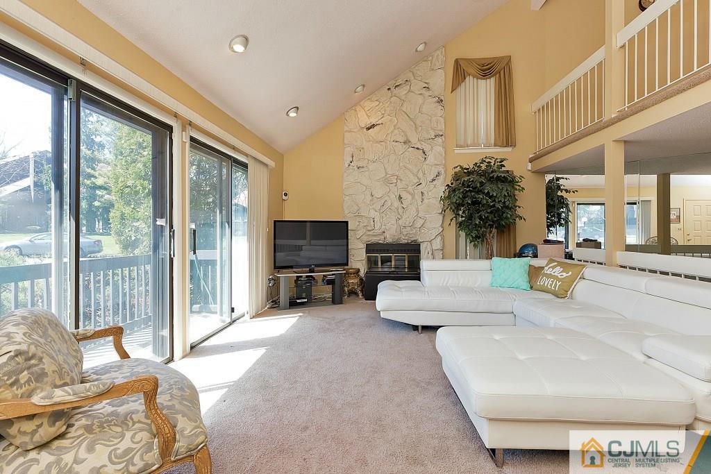 a living room with fireplace furniture and a large window