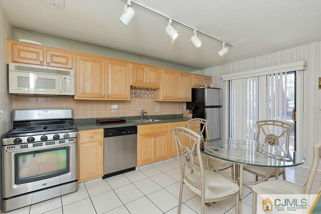 157 Westgate Drive Edison, NJ 08820 - Photo 5 of 12 a kitchen with granite countertop a stove top oven microwave and cabinets
