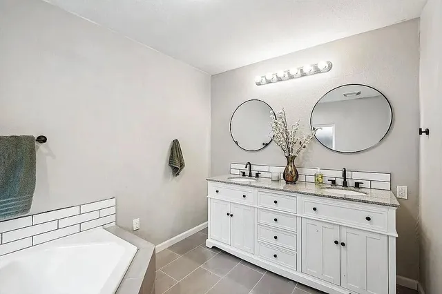 a bathroom with a double vanity sink and a mirror