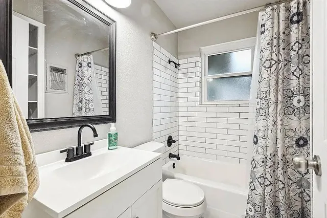 a bathroom with a sink toilet and shower