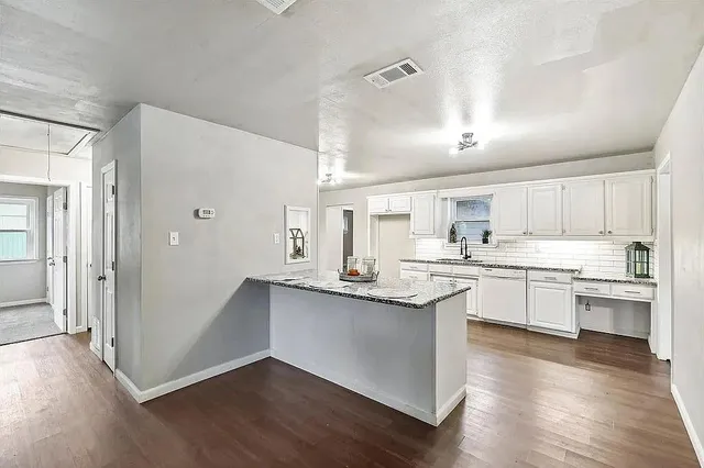 a kitchen with granite countertop white cabinets and white appliances