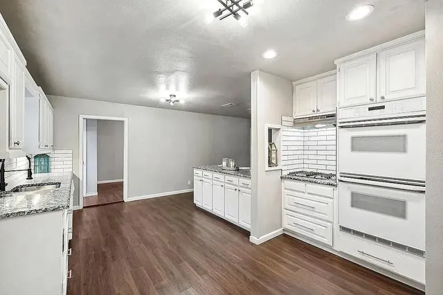 a kitchen with white cabinets and stainless steel appliances