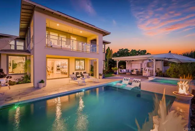 a view of a house with pool lawn chairs and a yard
