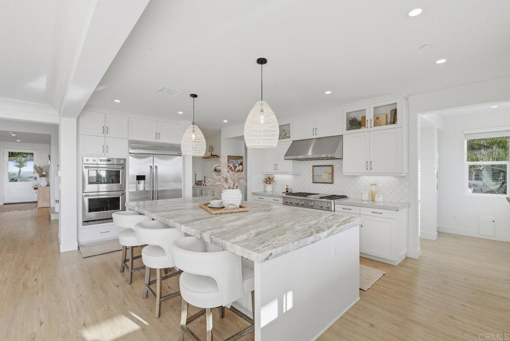 870 Hymettus Avenue Encinitas, CA 92024 - Photo 17 of 74 a large kitchen with kitchen island a stove a table a sink and a refrigerator