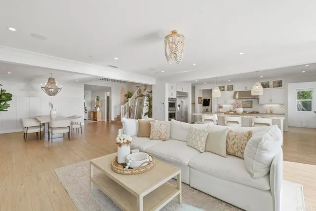 a kitchen with stainless steel appliances kitchen island granite countertop a table chairs and a refrigerator