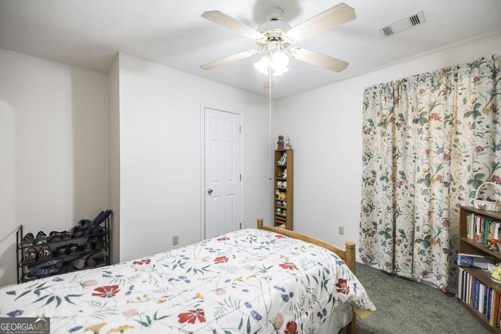 904 Robinhood Road Dublin, GA 31021 - Photo 19 of 29 a bedroom with a bed dresser and a chandelier