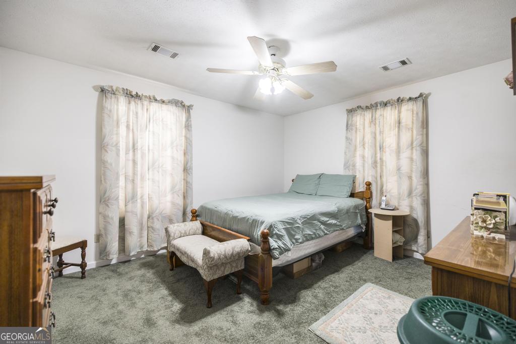 904 Robinhood Road Dublin, GA 31021 - Photo 22 of 29 a bedroom with a bed and a chandelier
