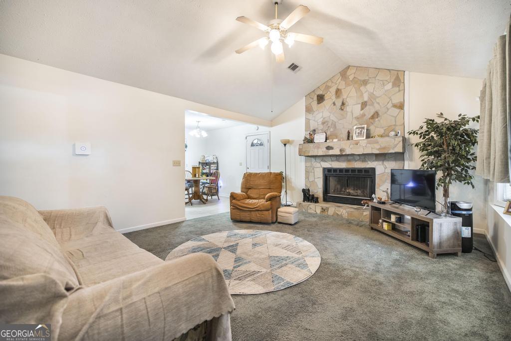 904 Robinhood Road Dublin, GA 31021 - Photo 8 of 29 a living room with furniture a fireplace and a chandelier