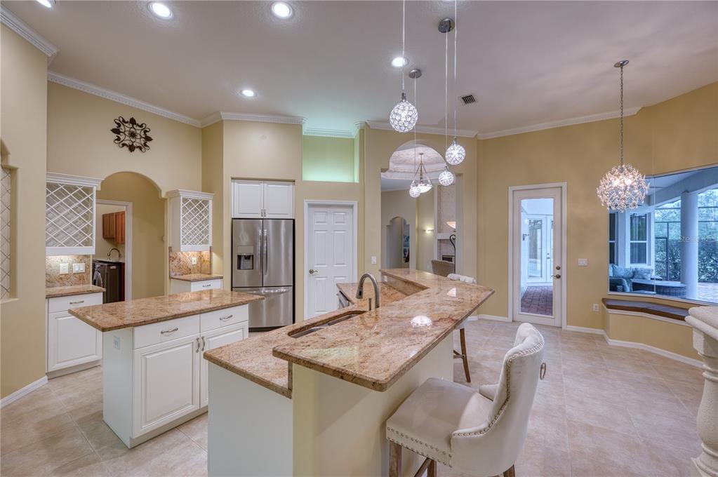 10523 Cheval Place Lakewood Ranch, FL 34202 - Photo 42 of 52 a kitchen with stainless steel appliances kitchen island granite countertop a sink and cabinets