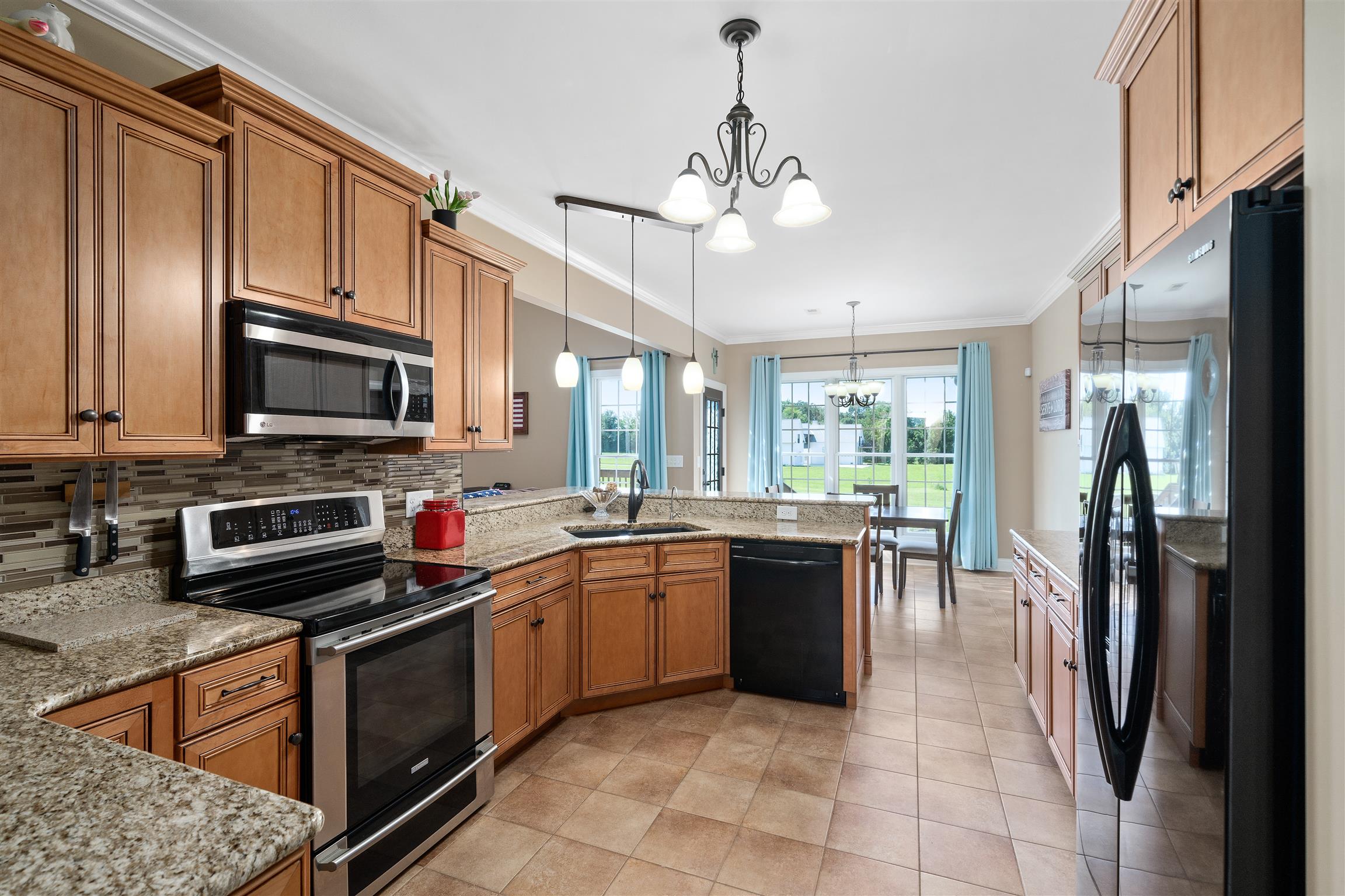 2570 Gunn Road Adams, TN 37010 - Photo 11 of 27 a kitchen with stainless steel appliances granite countertop a refrigerator a stove top oven a sink dishwasher a dining table and chairs with wooden floor