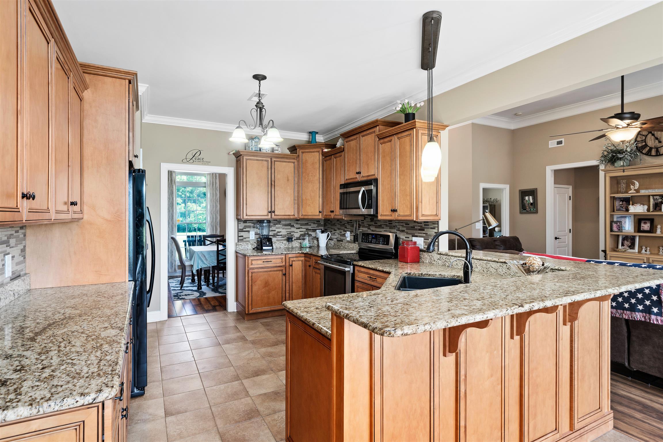 2570 Gunn Road Adams, TN 37010 - Photo 12 of 27 a kitchen with kitchen island granite countertop a stove a sink a oven and a dining table with wooden floor