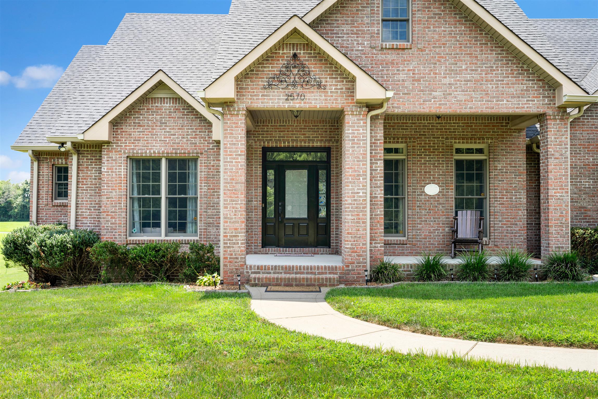 2570 Gunn Road Adams, TN 37010 - Photo 3 of 27 a view of a house with brick walls and a yard with potted plants