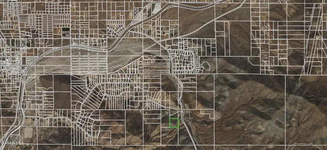 a view of a dry yard with mountains in the background