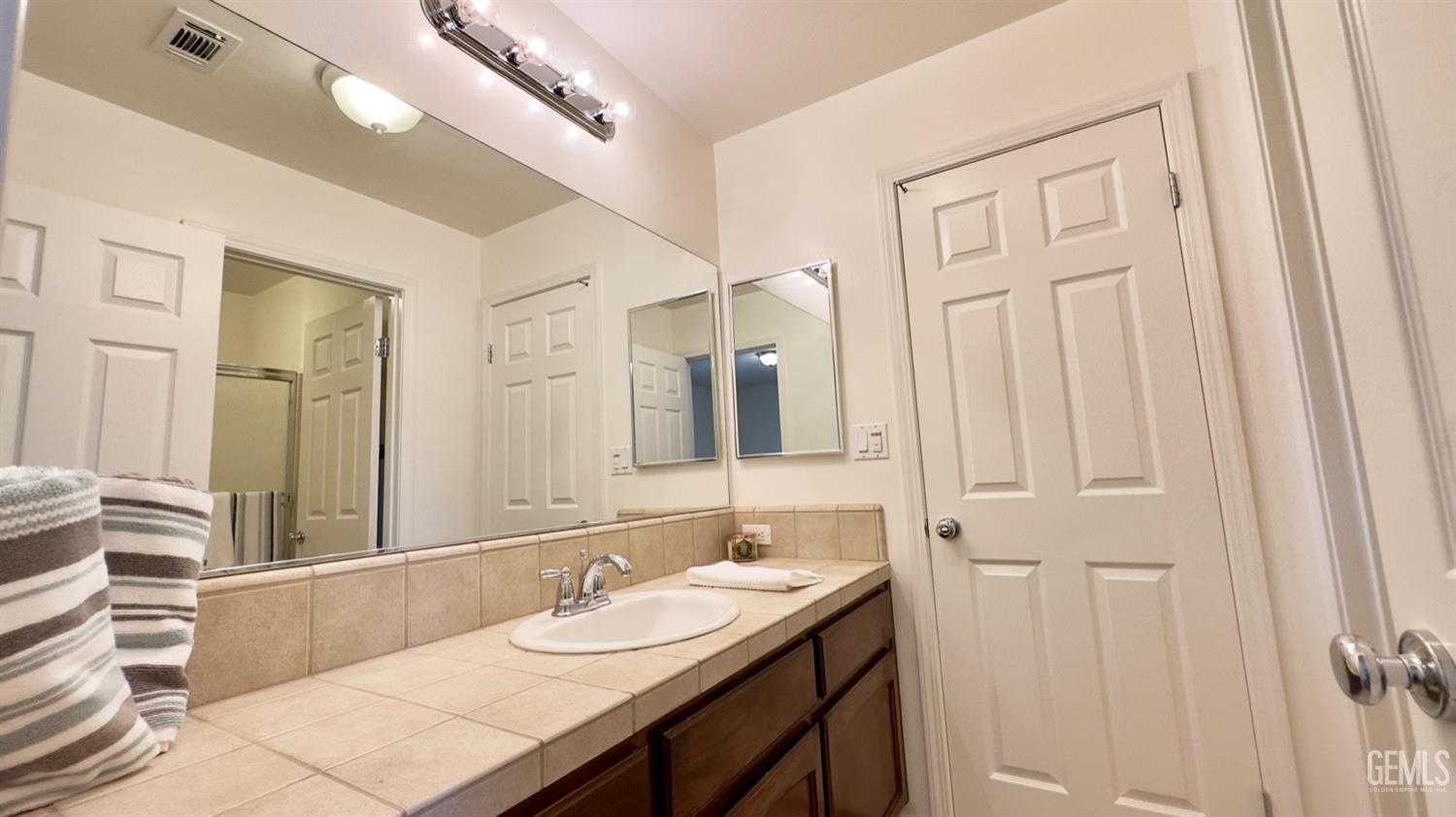 Undisclosed Address Bakersfield, CA 93311 - Photo 13 of 48 a bathroom with a sink and a mirror