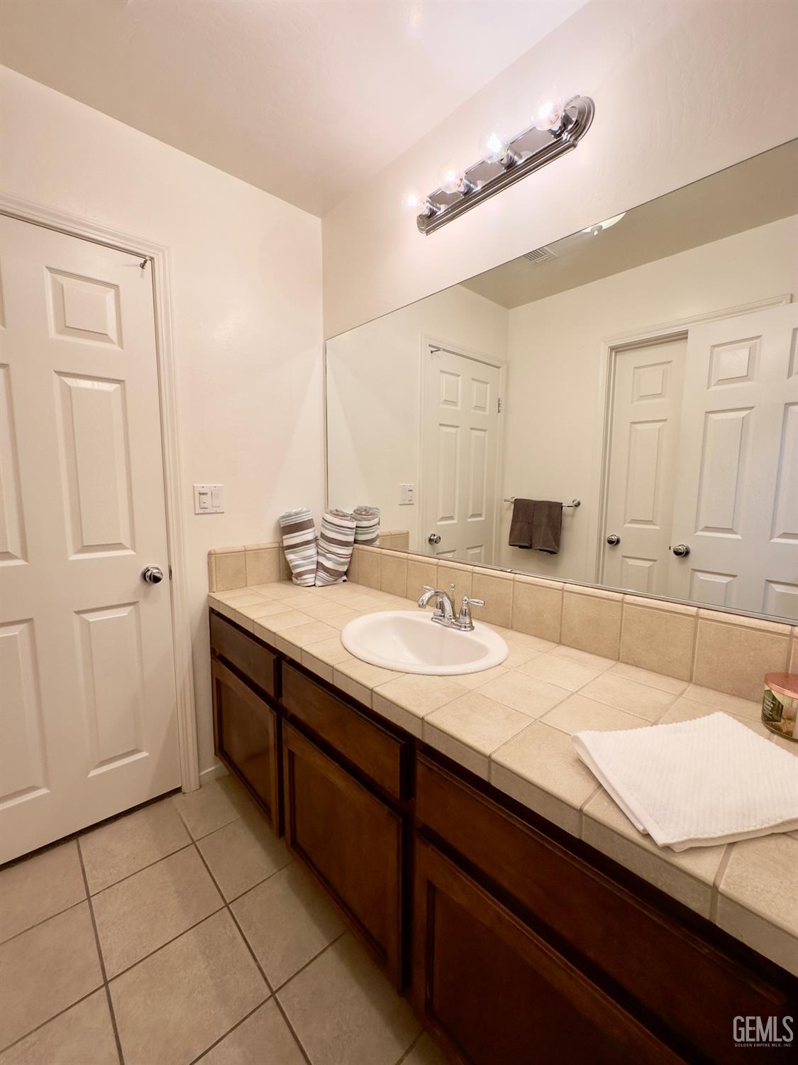Undisclosed Address Bakersfield, CA 93311 - Photo 14 of 48 a bathroom with a granite countertop sink and a mirror
