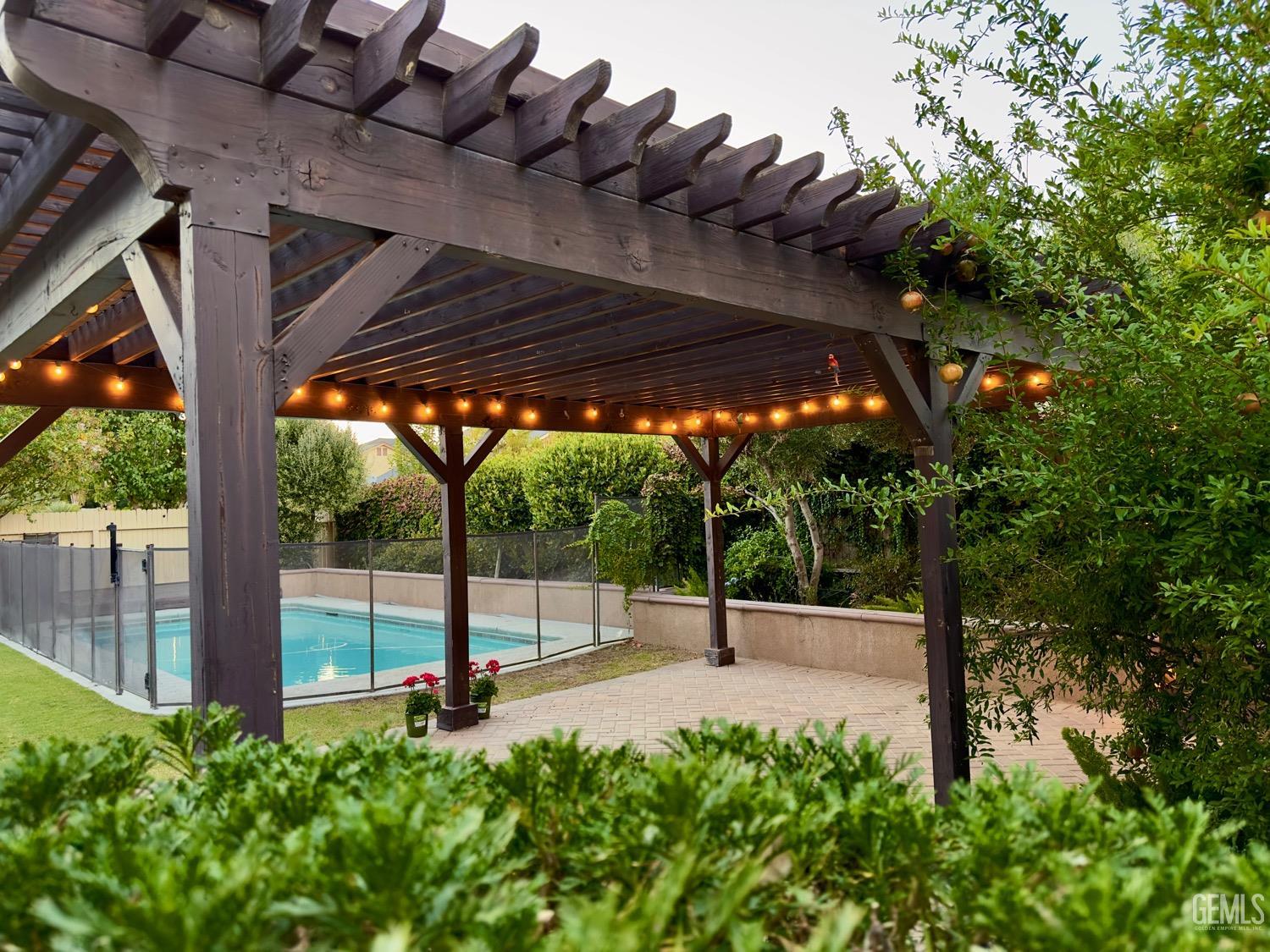 Undisclosed Address Bakersfield, CA 93311 - Photo 40 of 48 a view of a patio with table and chairs under an umbrella with a large tree