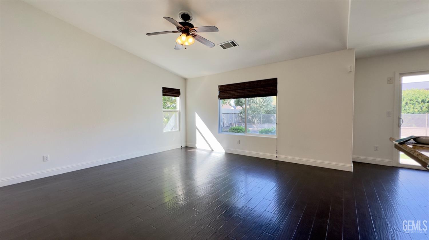 Undisclosed Address Bakersfield, CA 93311 - Photo 8 of 48 an empty room with wooden floor chandelier fan and windows