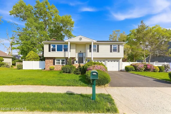 a front view of a house with a garden and yard