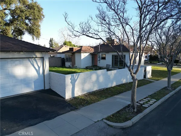 a view of swimming pool with lawn chairs and large trees