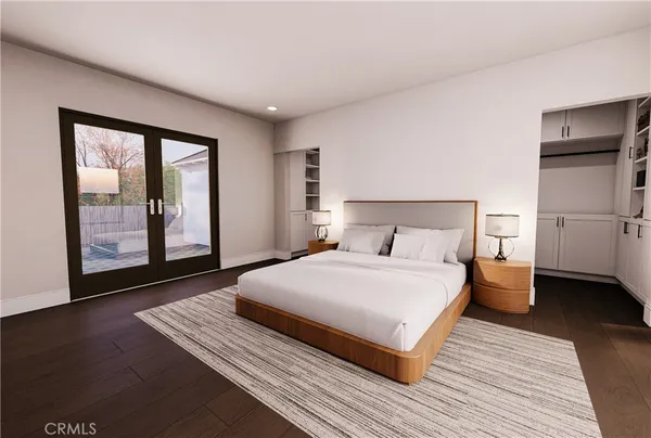 a bedroom with a large bed and wooden floor