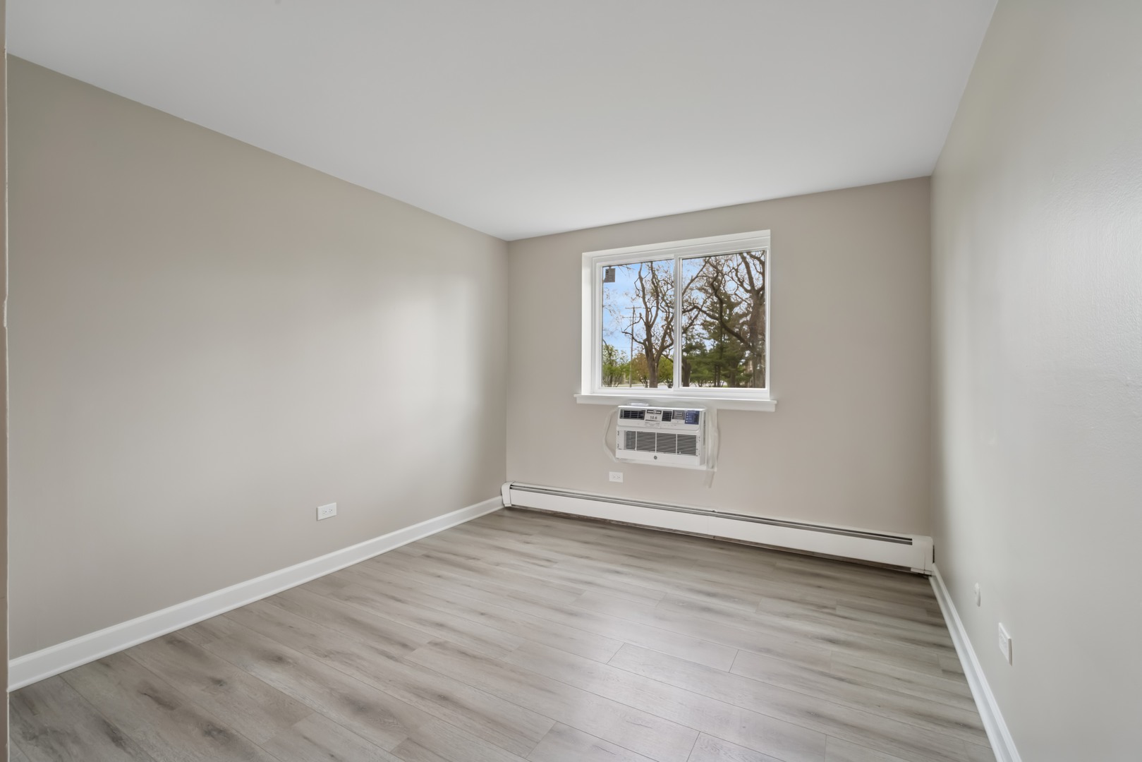1500 Robin Circle, Unit 101 Hoffman Estates, IL 60169 - Photo 9 of 20 an empty room with wooden floor and window