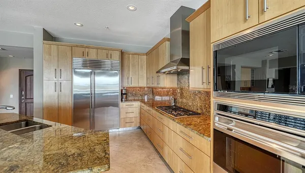 a kitchen with stainless steel appliances granite countertop a refrigerator and a sink