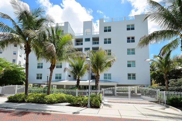 a front view of multiple houses with palm trees