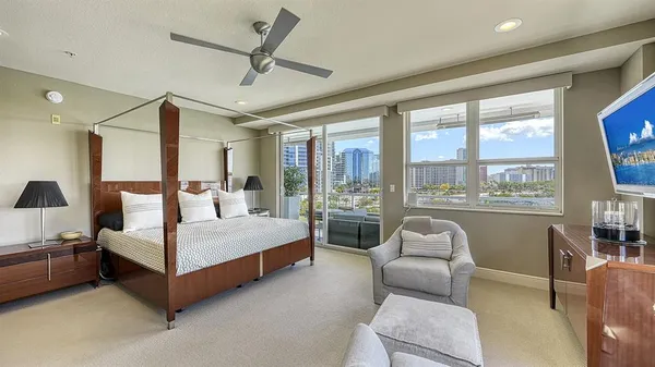 a bedroom with a bed couch and large window