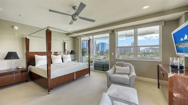 a bedroom with a bed couch and large window