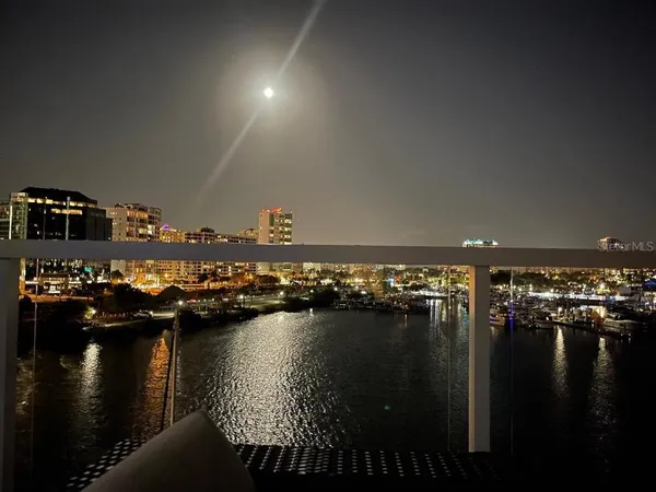 a view of ocean with boats and trees in the background