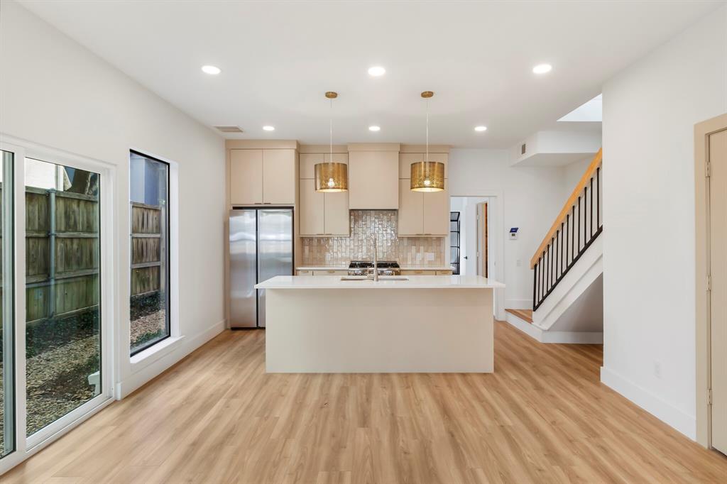 a view of kitchen with stainless steel appliances granite countertop cabinets and wooden floor