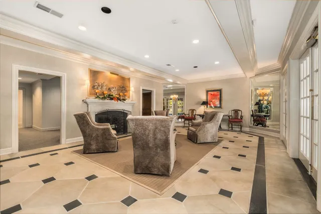 a living room with fireplace furniture and a rug