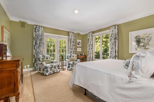 a bed sitting in a spacious bedroom next to a window