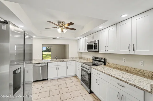 a kitchen with a sink stainless steel appliances and white cabinets
