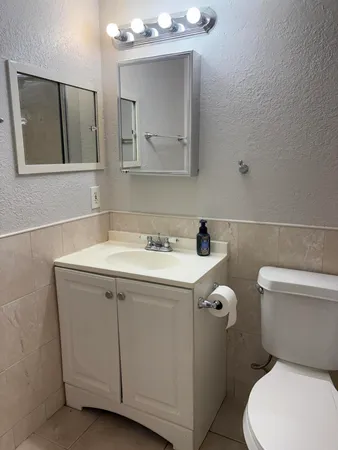 a bathroom with a sink a toilet and mirror