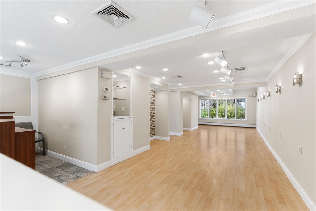 231 Bedford Street Lexington, MA 02420 - Photo 8 of 31 a view of a hallway with wooden floor and a kitchen