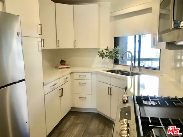 a kitchen with white cabinets and white appliances
