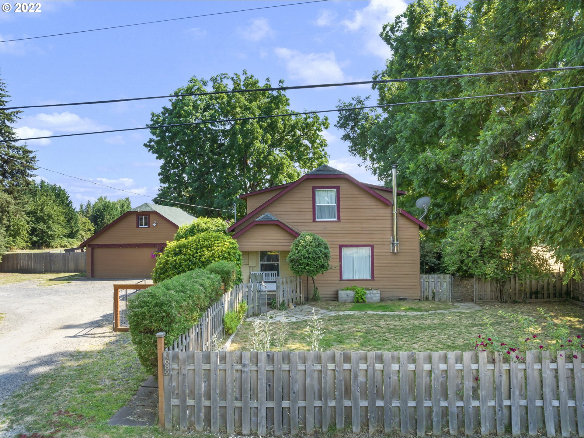 1689 Southwest Stringtown Road Forest Grove, OR 97116 - Photo 2 of 28 a front view of a house with a yard and garage