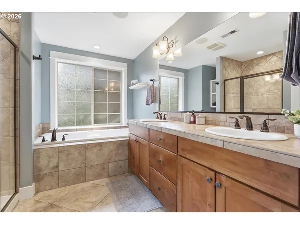 a bathroom with a tub sink and mirror