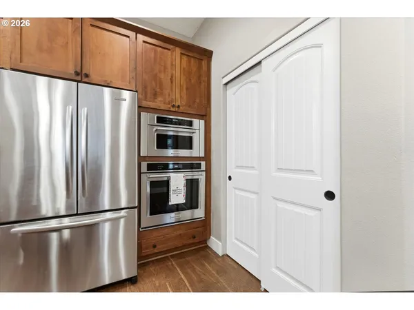 a view of kitchen with stainless steel appliances wooden floor