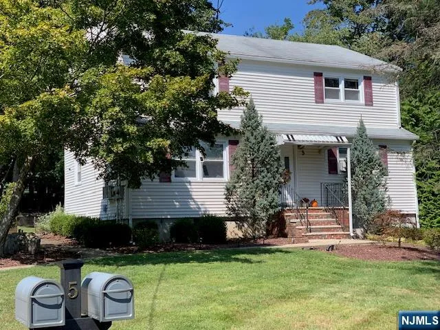 a front view of a house with a garden and plants