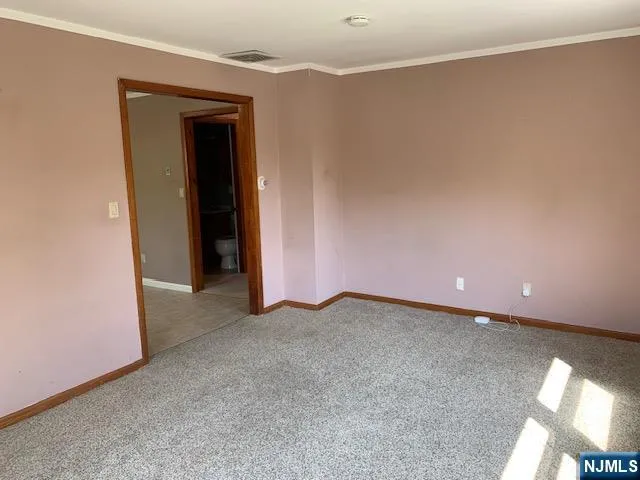 an empty room with closet and a hallway